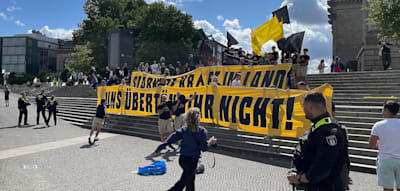 „Remigration“-Rufe stören ARD-„Sommerinterview“ mit Söder – Polizisten fixieren Demonstranten